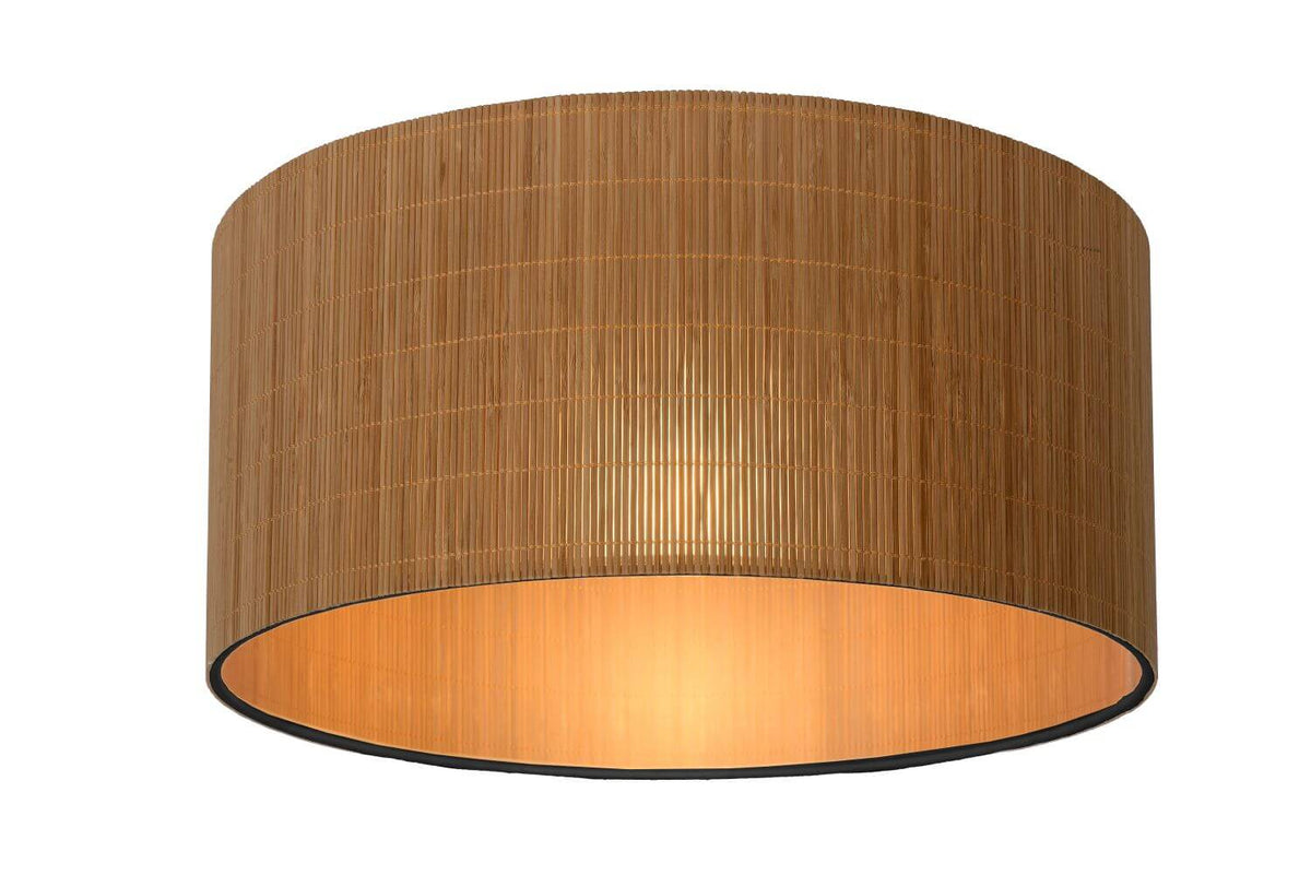 Produit de face sur fond blanc, abat-jour cylindrique en rotin et intérieur doré.