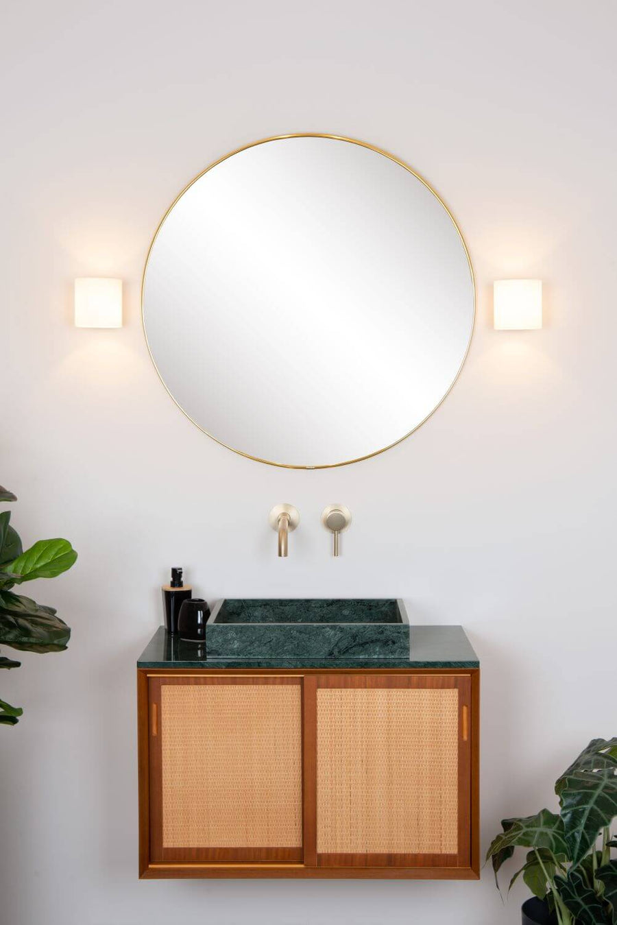 Vue frontale des deux appliques allumées de part et d'autre du miroir doré