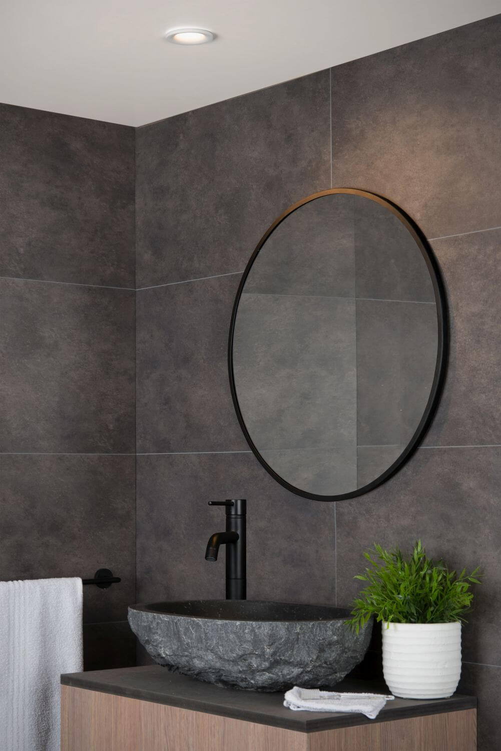Vue d'ambiance d'une salle de bain moderne avec le spot blanc encastré au plafond.
