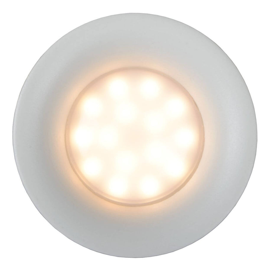 Face avant du luminaire allumé, modules LED visibles répartis en cercle.