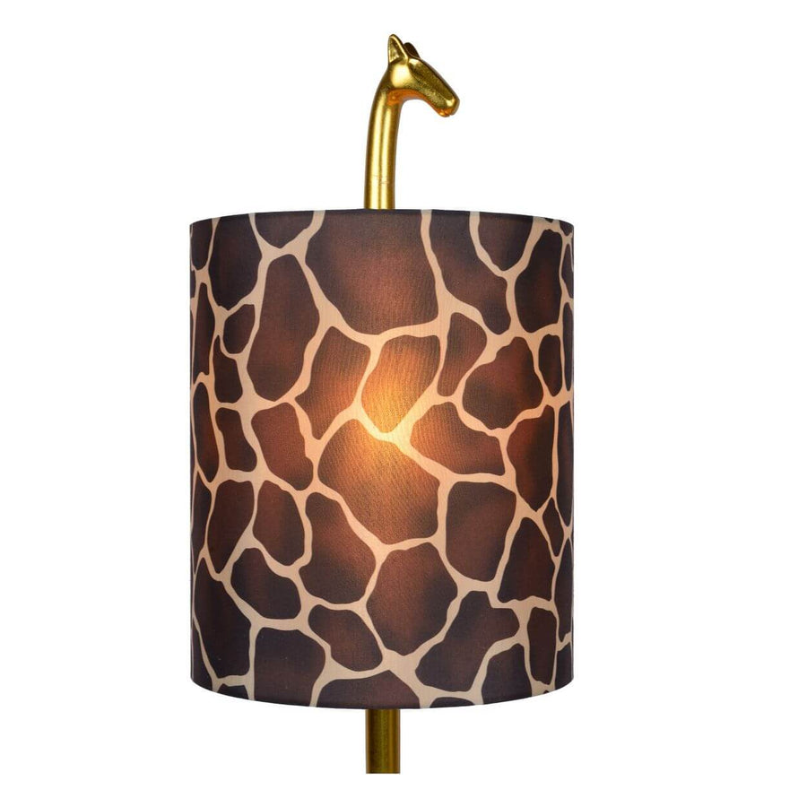 Gros plan sur l'abat-jour cylindrique en coton, motif girafe, ampoule allumée.
