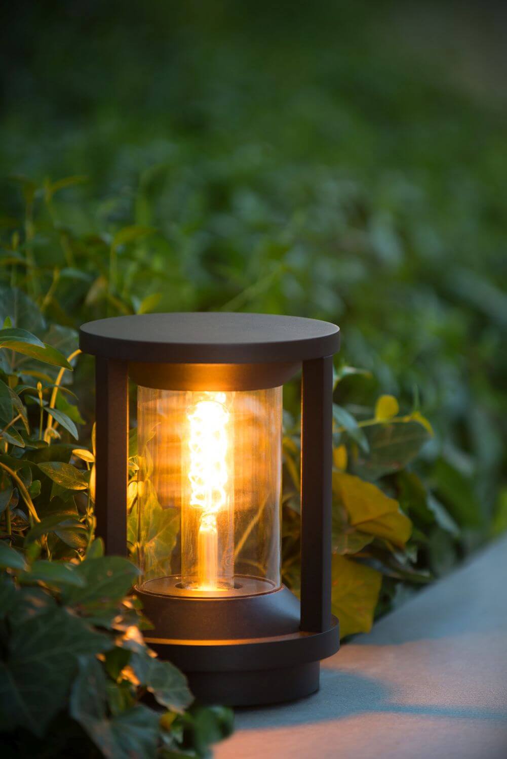 Ambiance de jardin au crépuscule, borne lumineuse éclairant les plantes alentour