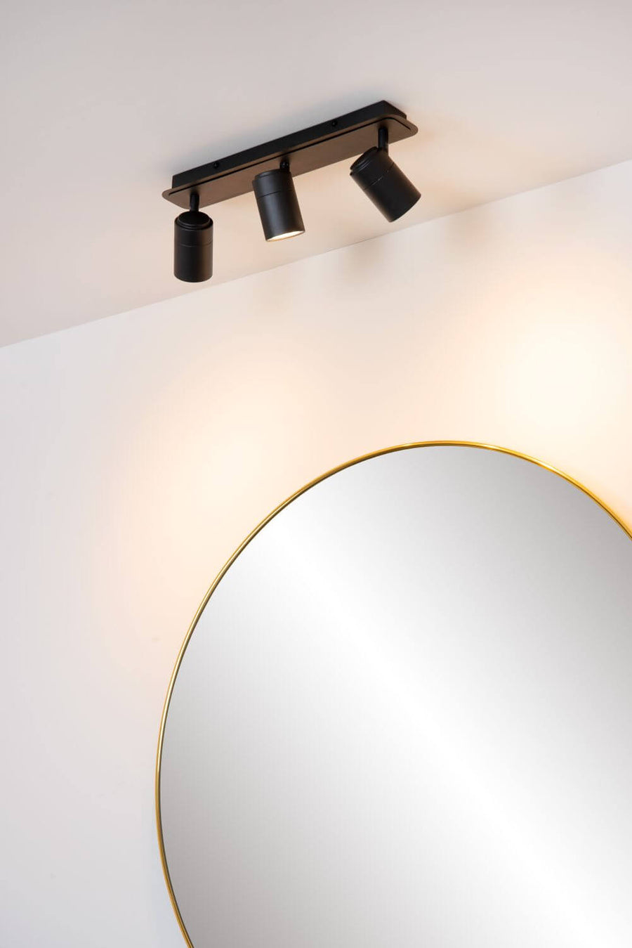 Vue en plongée du plafonnier noir fixé au plafond, spots orientés vers le miroir.