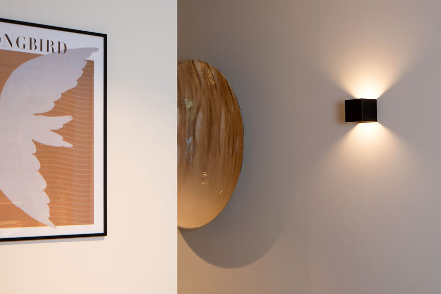 Vue de face de l'applique noire fixée au mur, éclairant vers le haut et le bas