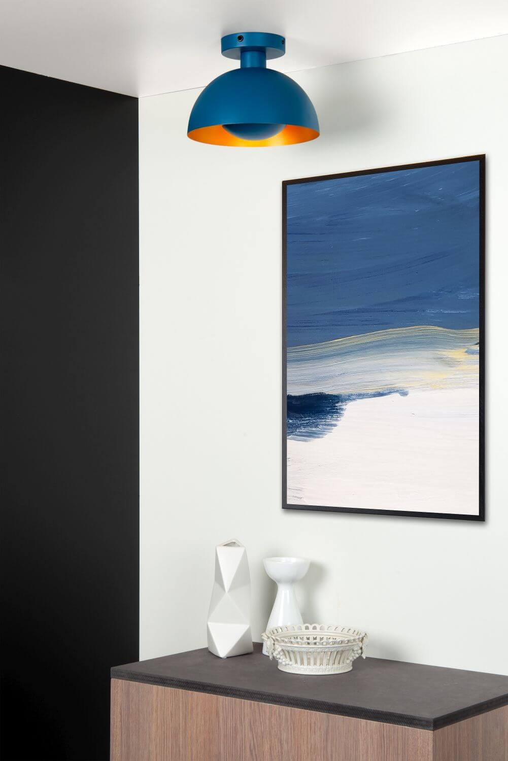 Plafonnier bleu installé au plafond près d'une peinture abstraite et d'un meuble