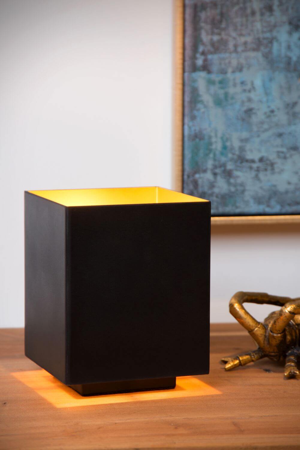 Mise en ambiance avec lampe cube noire dorée et crabe doré sur bois.
