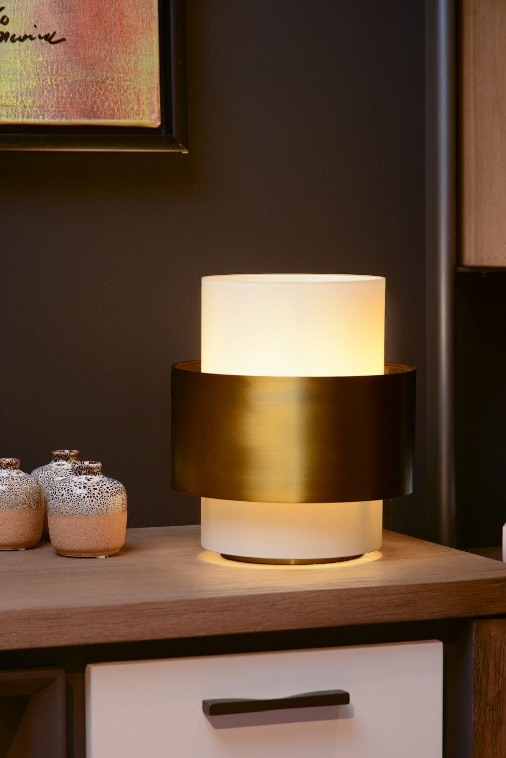 Mise en ambiance sur un meuble avec tableau encadré et mur sombre