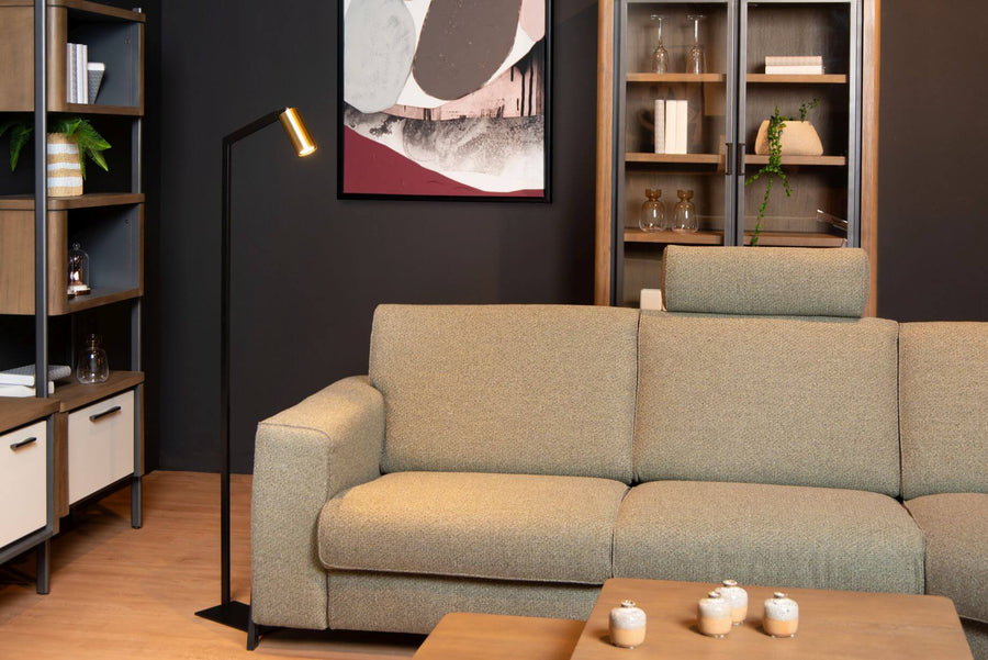 Ambiance salon moderne, lampadaire éclairant un canapé beige et une vitrine