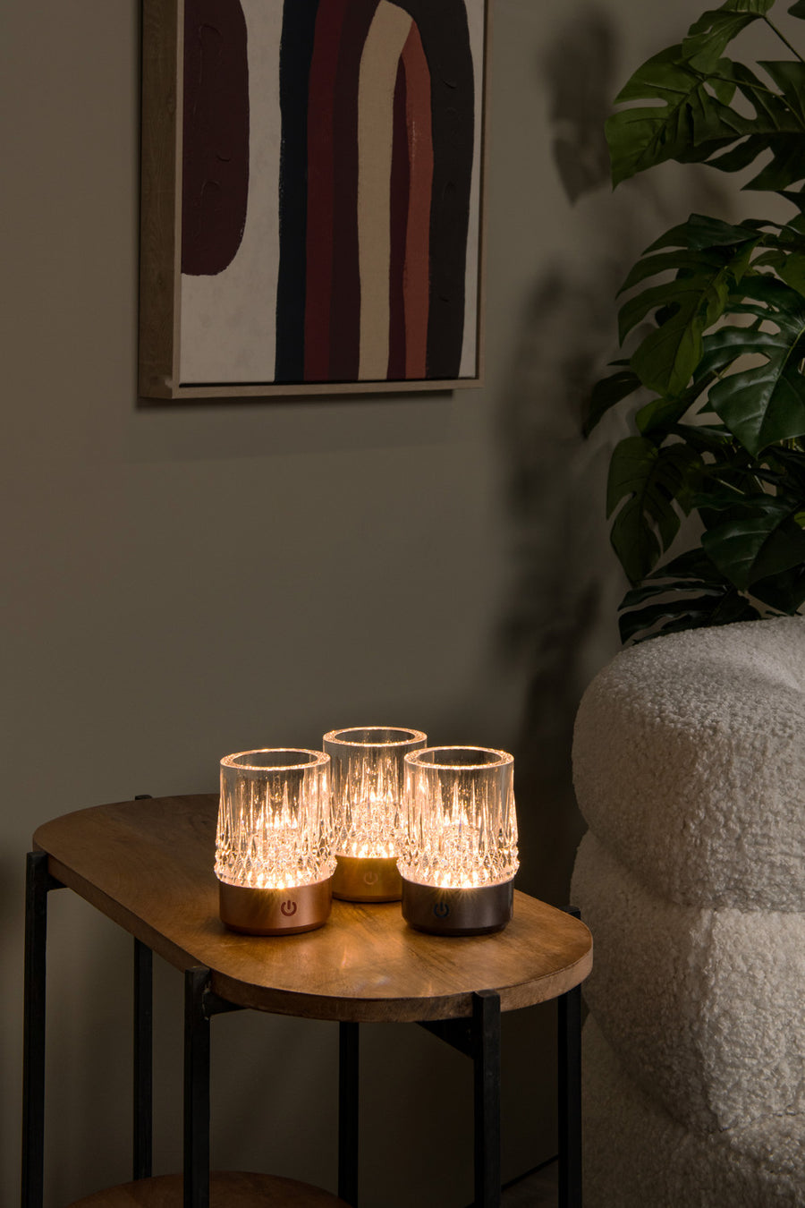 Trois lampes rechargeables allumées ensemble sur une table ronde en bois