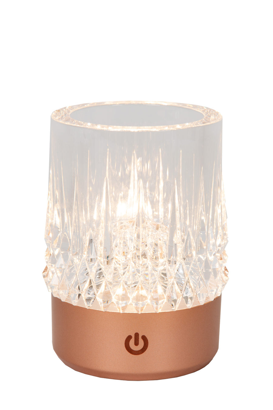 Gros plan de la lampe cuivrée allumée, révélant le verre facetté et la lumière chaude.
