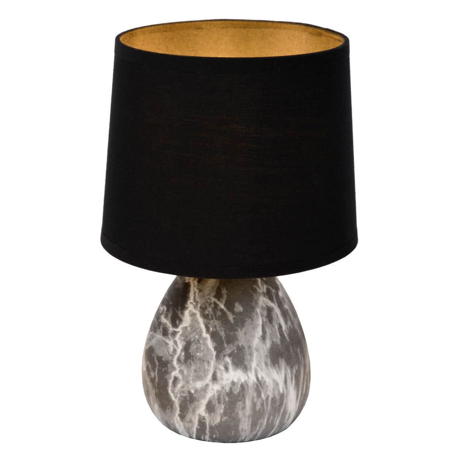 Détail de l'abat-jour noir révélant son intérieur doré, base marbrée blanche et grise.