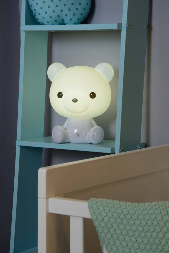 Vue rapprochée de la veilleuse allumée, montrant le visage d'ours sur l'étagère.