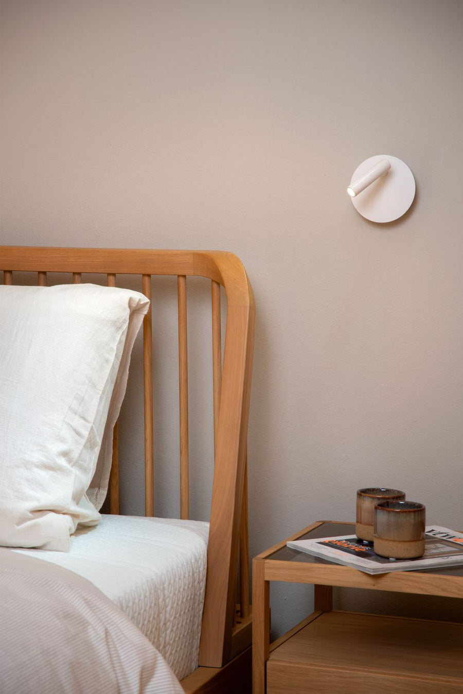 Vue rapprochée de l'applique murale blanche fixée près d'une tête de lit