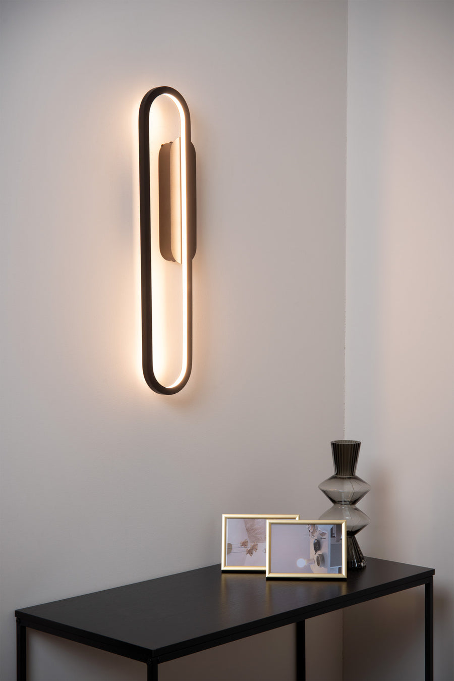 Vue d'ambiance rapprochée du luminaire mural éclairé dans un intérieur sobre et minimaliste