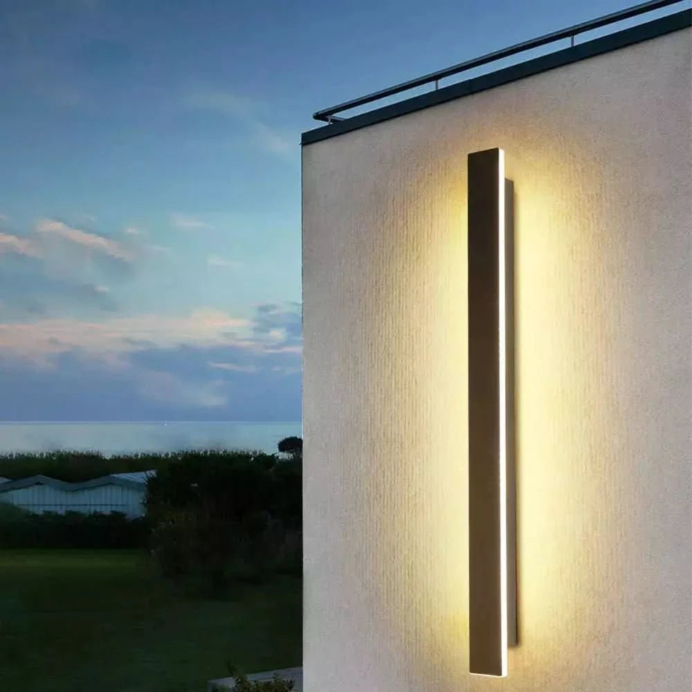 Produit de face sur mur crème, lumière chaude verticale devant un paysage marin