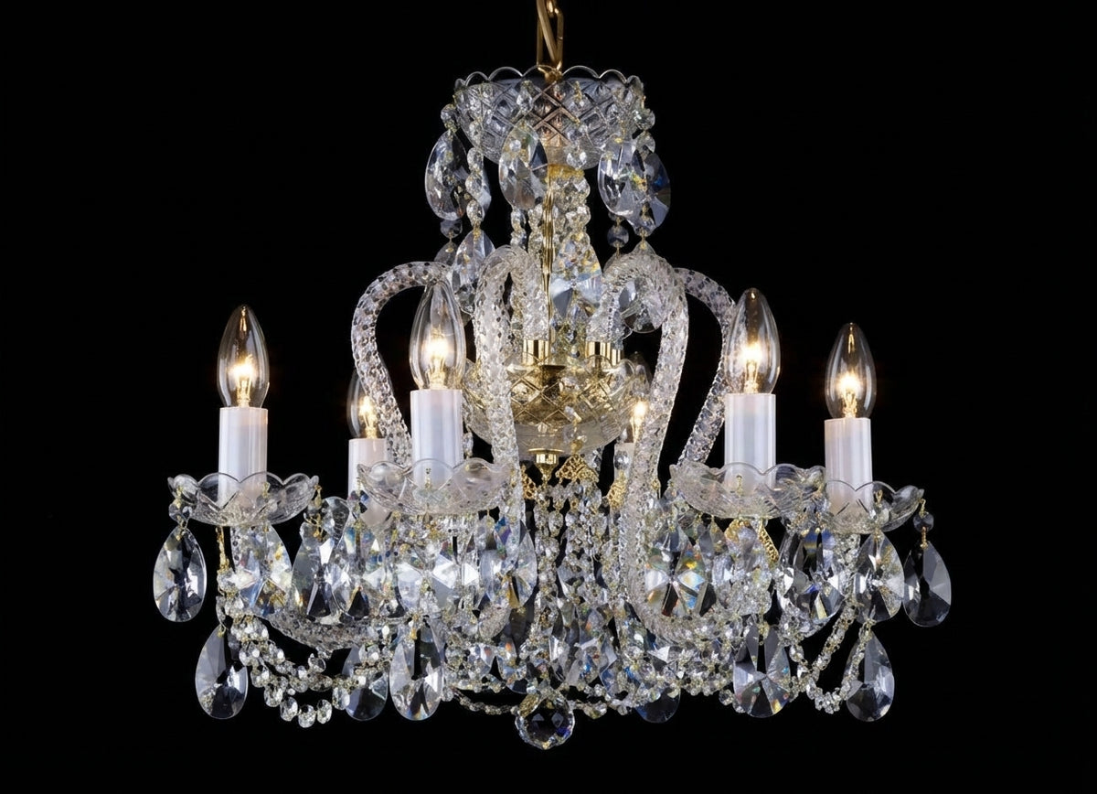 Lustre en cristal allumé, six ampoules visibles, vue de face sur fond noir.