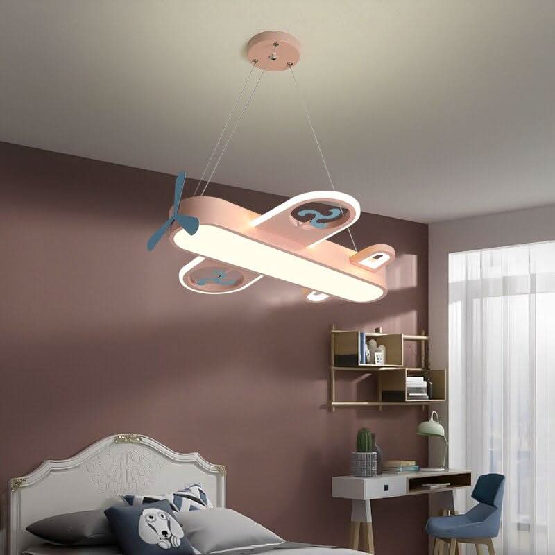 Luminaire avion rose suspendu dans une chambre mauve avec bureau et étagères.