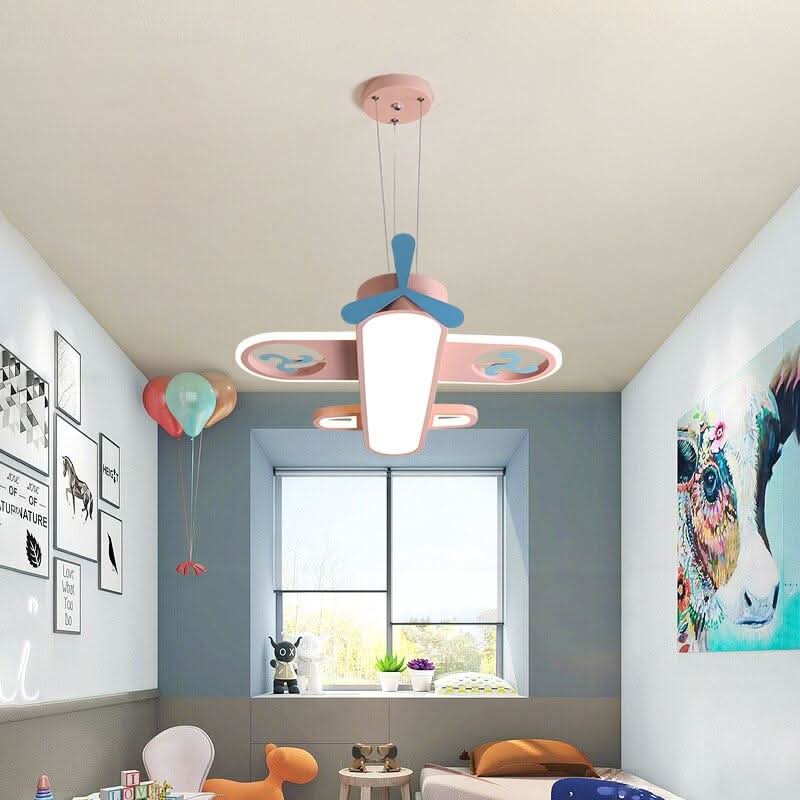 Vue en plongée d'un avion rose suspendu dans une chambre bleue avec grande fenêtre.
