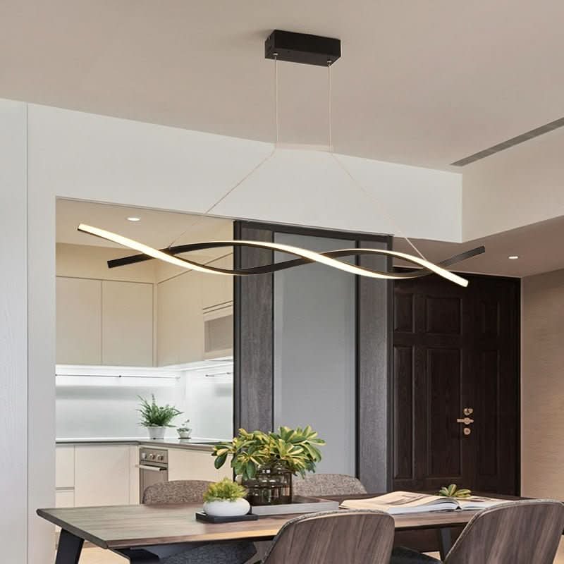 Suspension ondulée allumée au-dessus d'une table, intérieur sombre et cuisine en enfilade