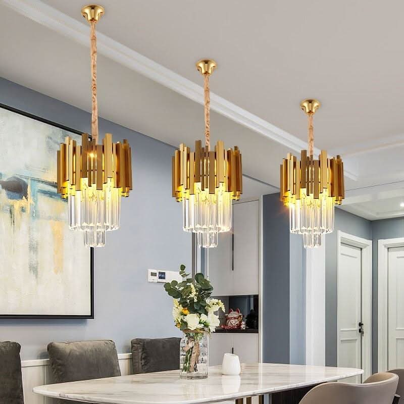 Lustre cristal moderne doré allumé au-dessus d’une table de salle à manger – Designix.fr