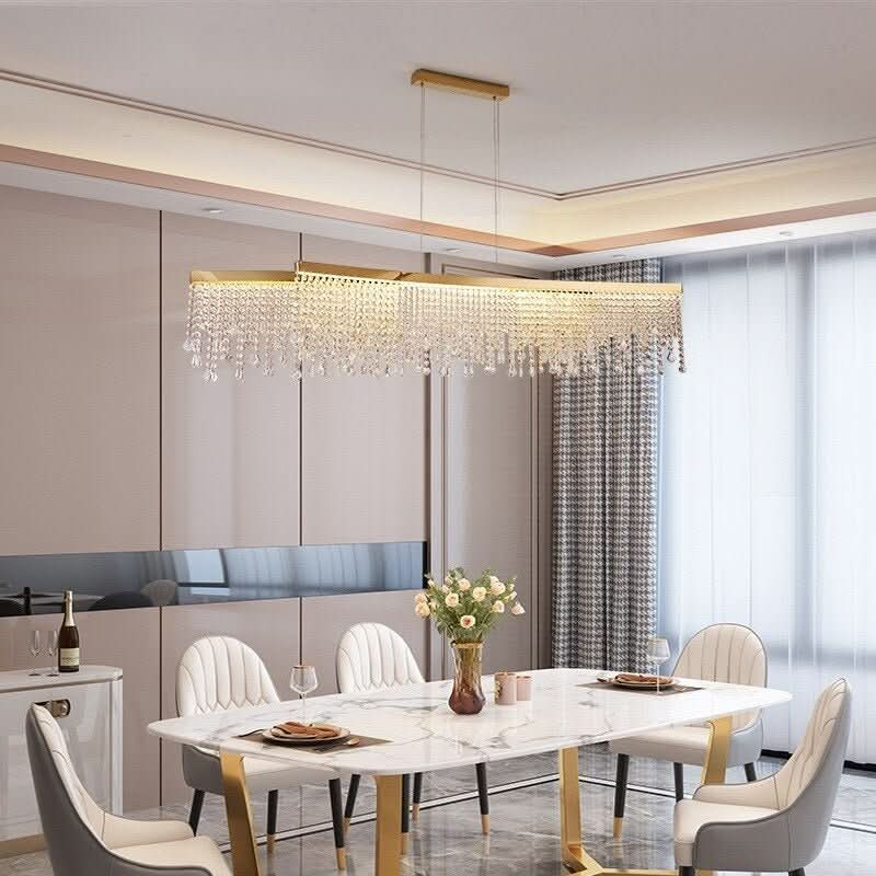 Luminaire doré rectangulaire éclairant une salle à manger moderne aux chaises blanches