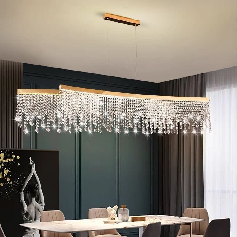 Grand lustre rectangulaire doré à franges de cristal au-dessus d'une table à manger