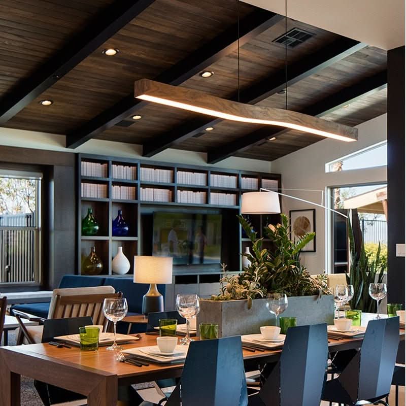 Vue du luminaire linéaire en bois éclairant une grande table de salle à manger