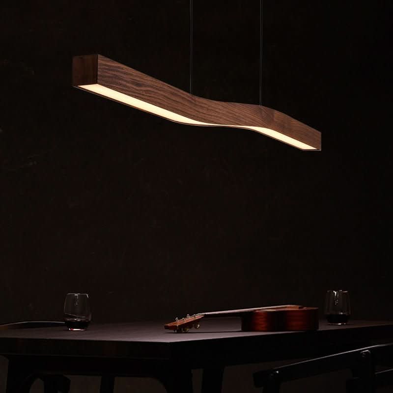 Détail du ruban lumineux en bois sur fond noir, guitare et verres posés