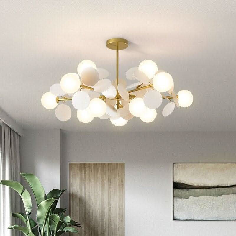 Version blanche du luminaire suspendu, disques et globes opalins sur tige dorée.