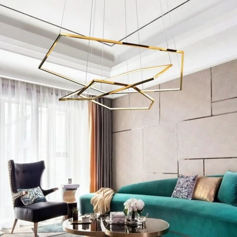 Luminaire suspendu doré éclairé dans un salon lumineux aux murs beiges et canapé vert