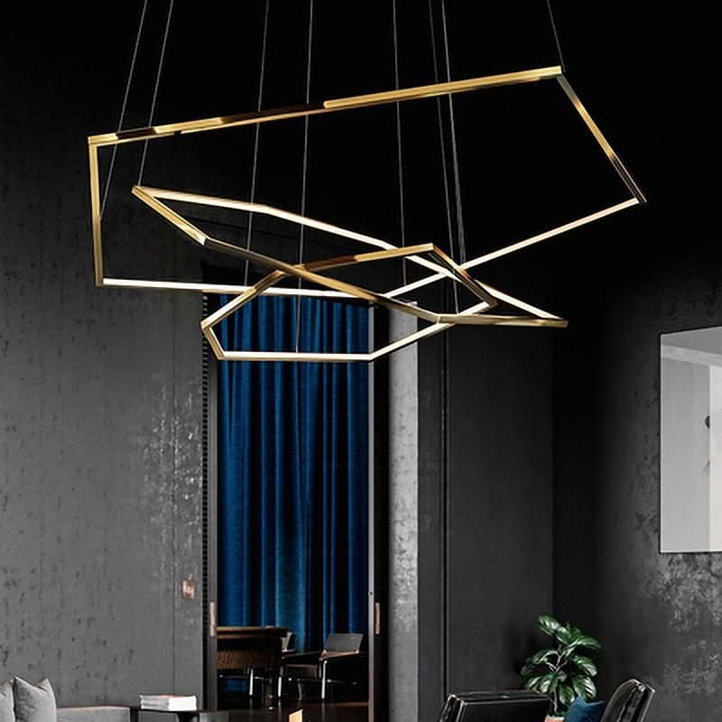 Silhouette du lustre doré allumé se détachant devant un mur sombre et des rideaux bleus