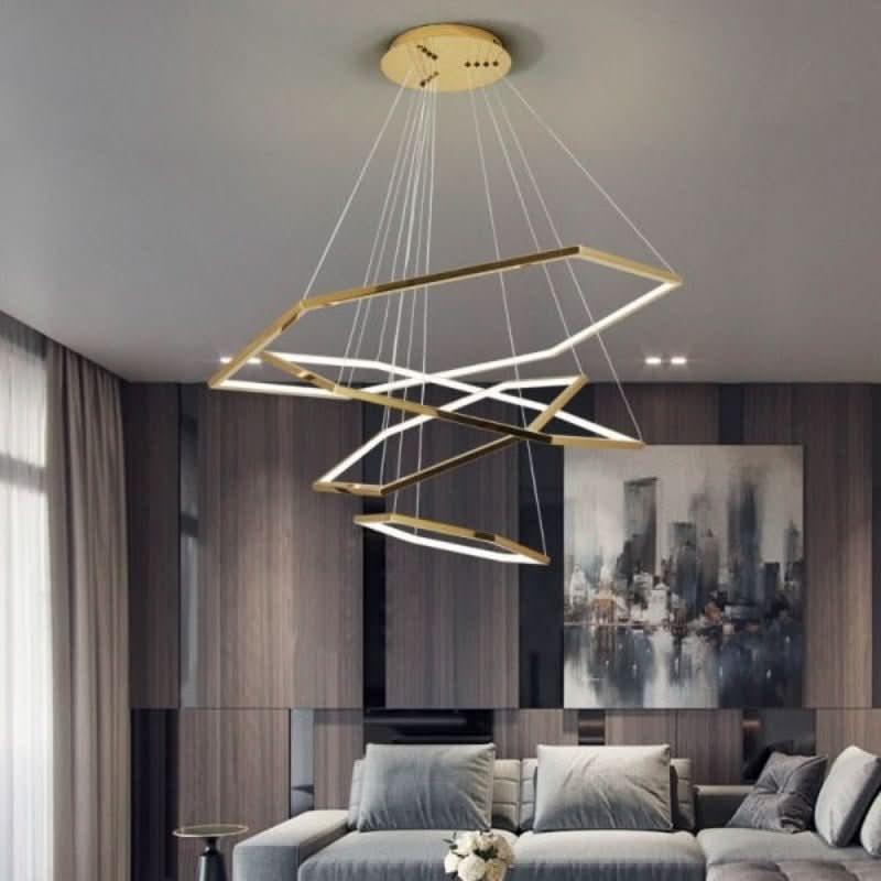 Détail du support plafond doré et des câbles fins du lustre dans un salon moderne