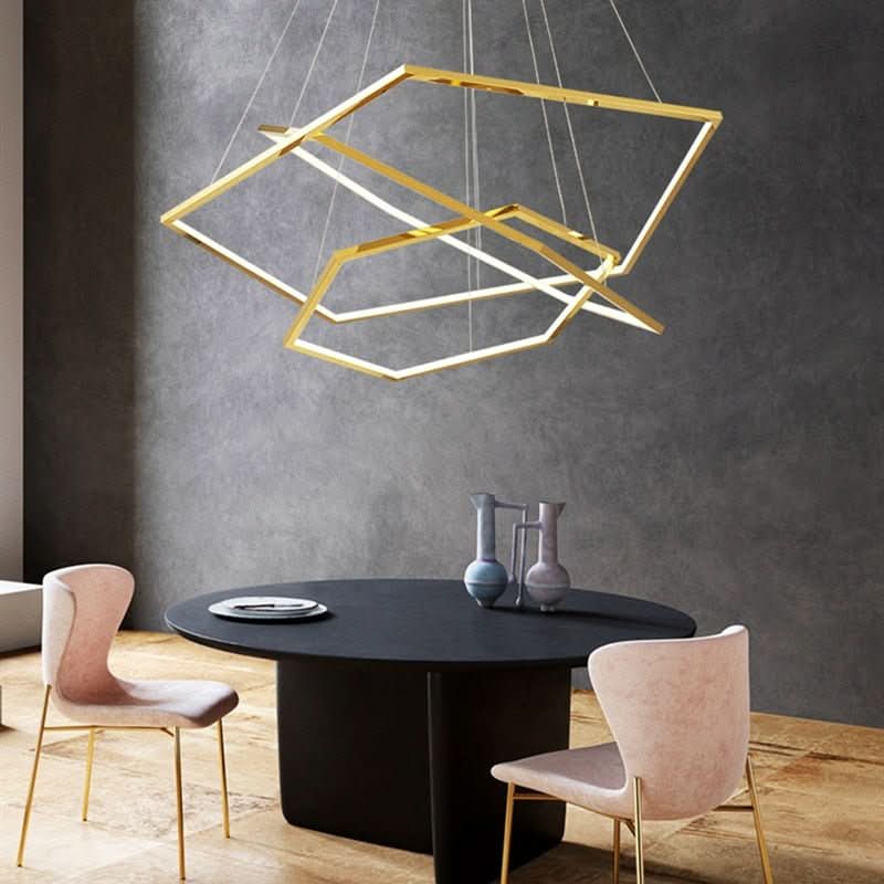Vue rapprochée du luminaire doré au-dessus d'une table ronde noire et de chaises roses