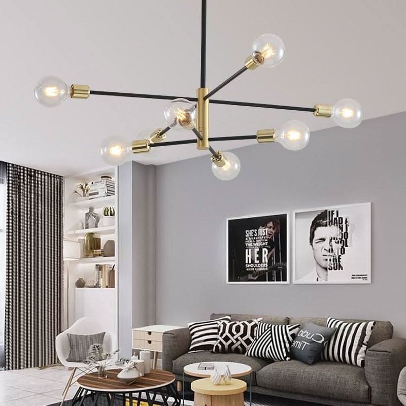 Lustre suspendu au plafond d'un salon, huit ampoules globes transparentes, structure noire et dorée.