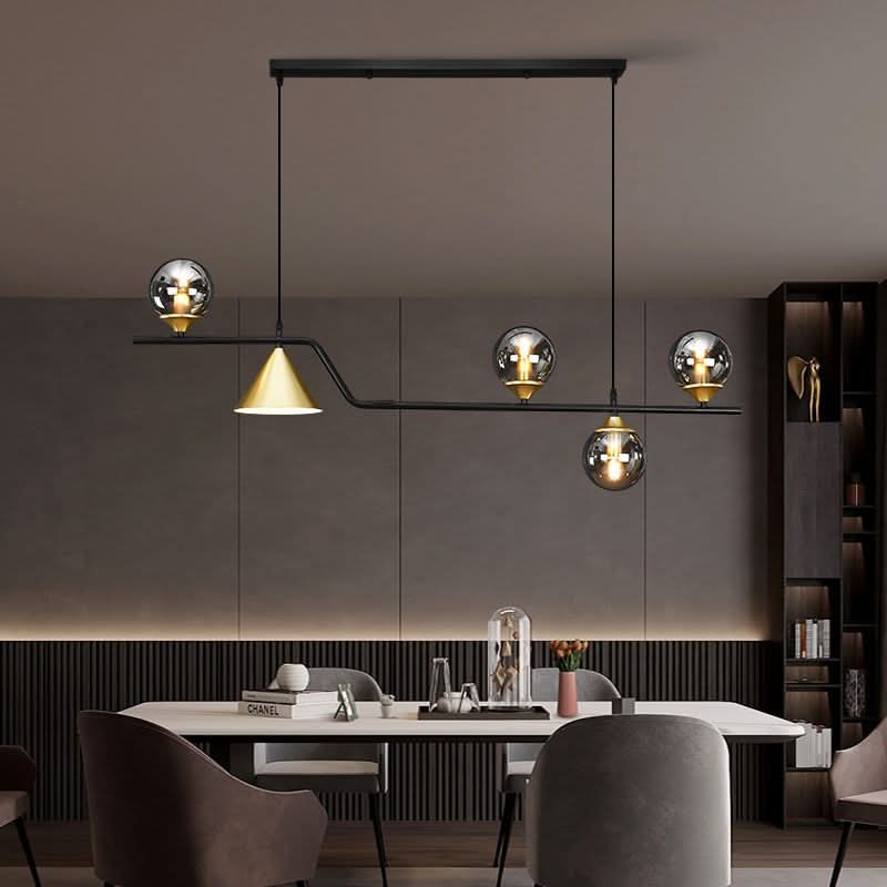 Mise en ambiance salle à manger, suspension au-dessus d'une table dressée, cône doré et globes fumés