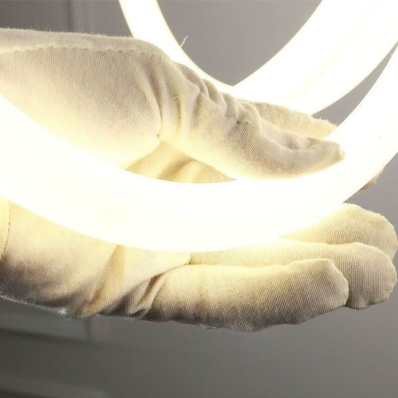 Détail d'un bras lumineux courbé tenu par une main gantée