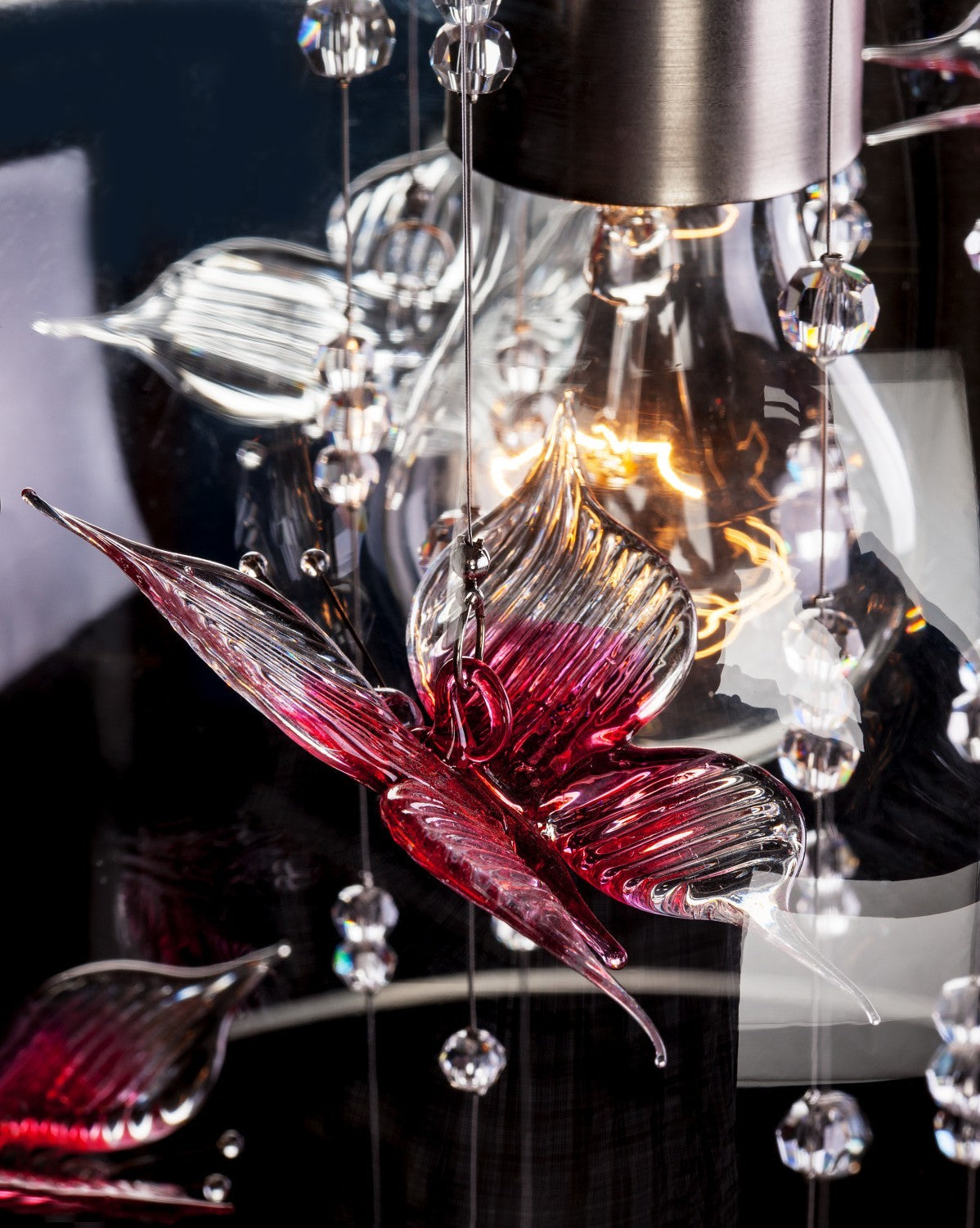 Détail macro d'un papillon en verre rose et perles facetées