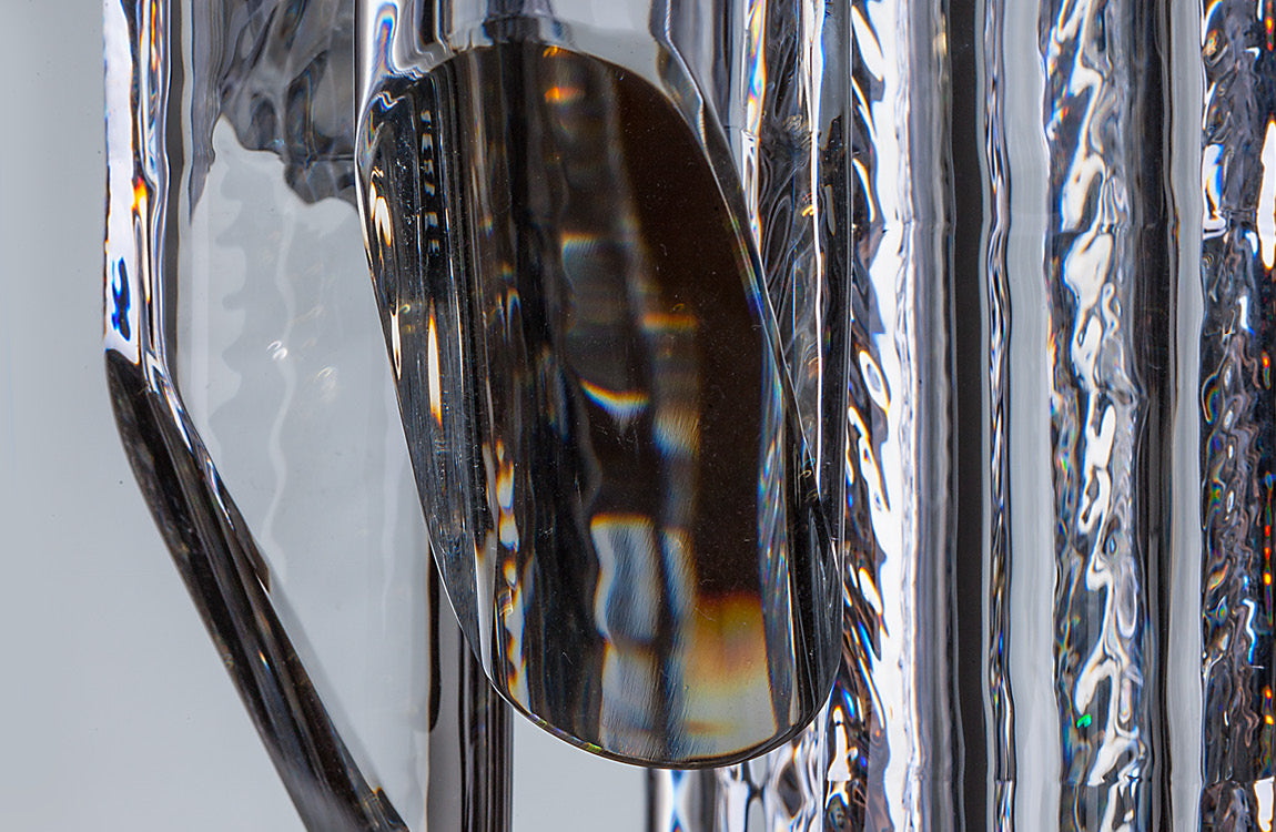 Détail rapproché du verre strié et de ses reflets ondulés sur la tige centrale
