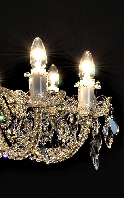 Détail des bras ciselés et pendeloques en cristal taillé avec ampoules en fleur