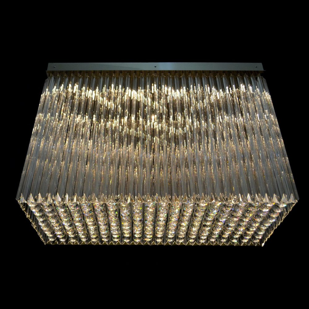 Détail du bas du luminaire, cristaux facettés éclairés formant un tapis scintillant