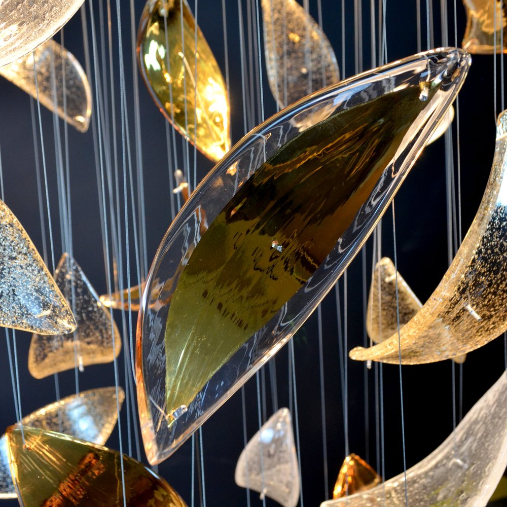 Gros plan sur une grande feuille de verre teintée, reflets ambrés et câbles fins