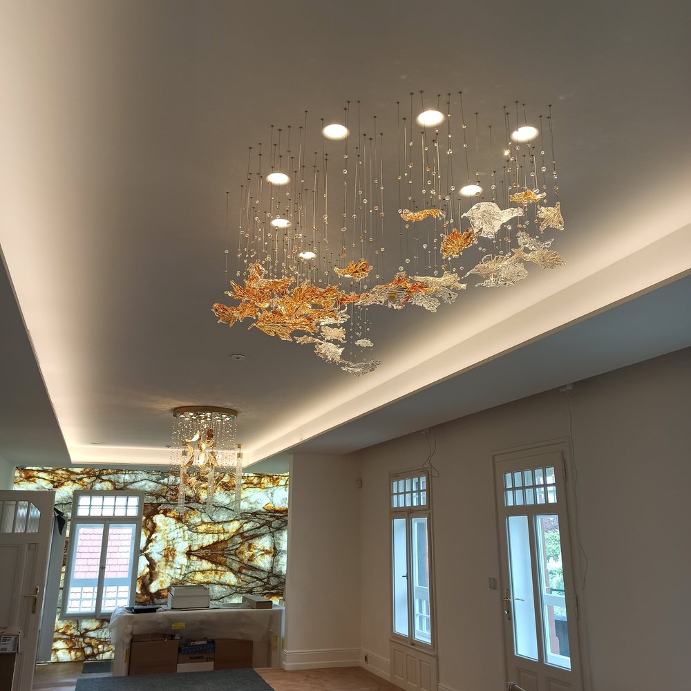 Vue d'ensemble dans un grand salon, longue guirlande de feuilles suspendues au plafond