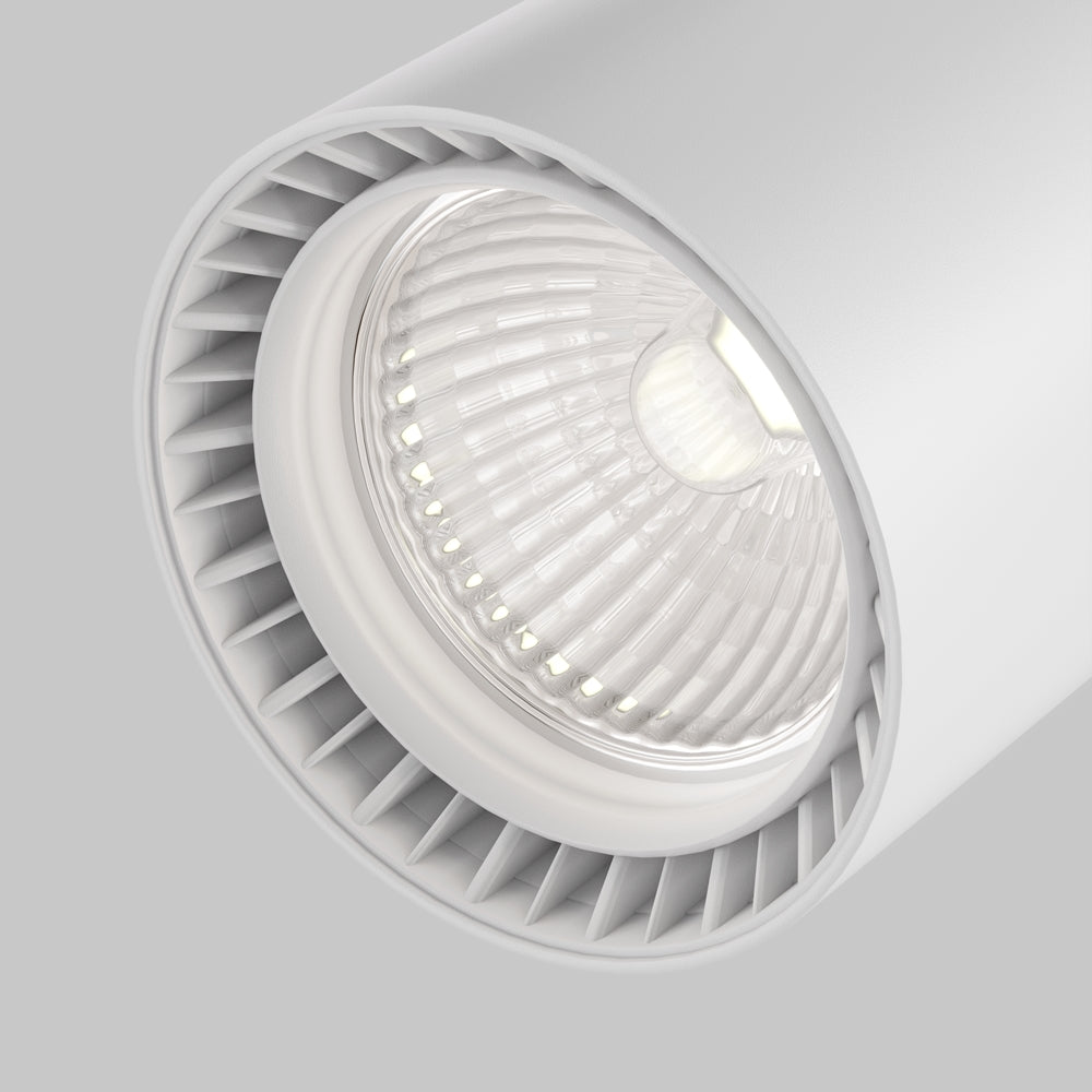 Gros plan sur la lentille striée et les ailettes du projecteur blanc