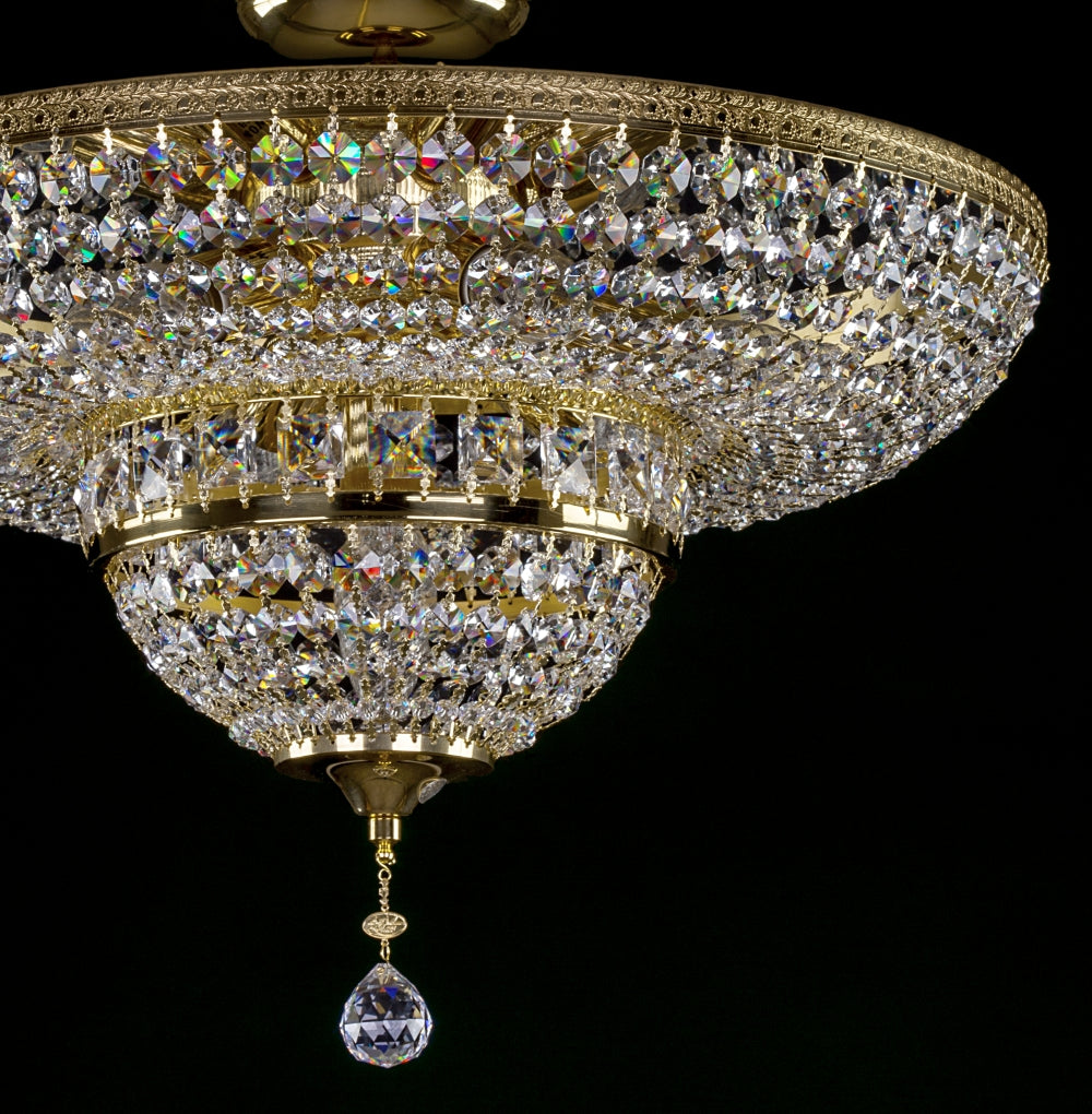 Gros plan du bas du luminaire avec bague dorée et goutte de cristal