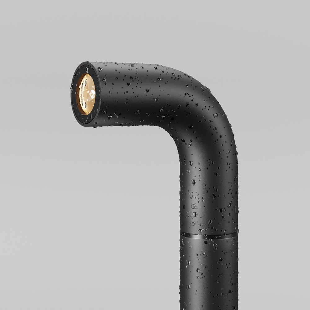 Tête du luminaire noire couverte de gouttes d'eau, résistance aux intempéries.
