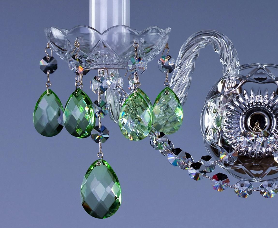 Gros plan sur les bras recourbés et les pendeloques vertes en cristal.