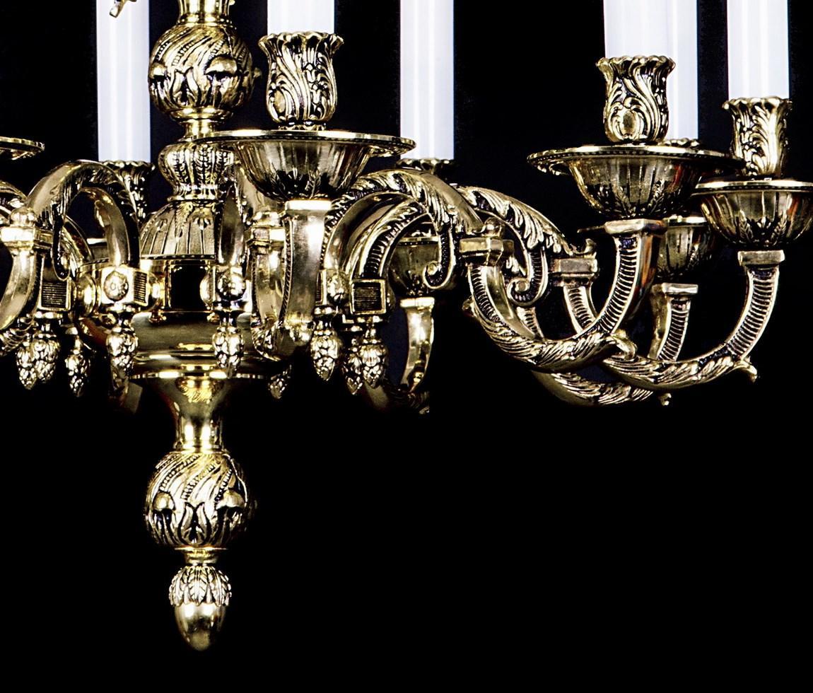 Détail des bras courbes ciselés, godrons, feuilles dorées et pendentif en bas du lustre