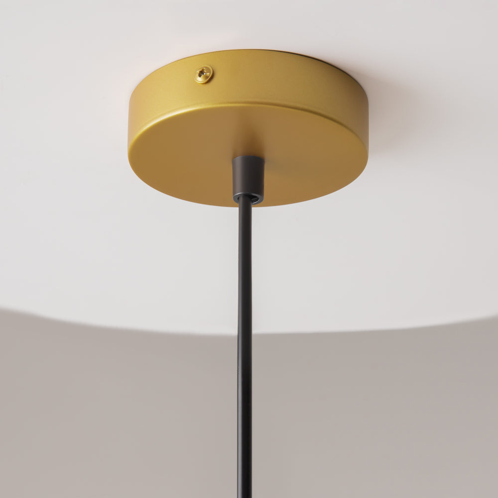 Détail de la rosace dorée fixée au plafond et du câble noir