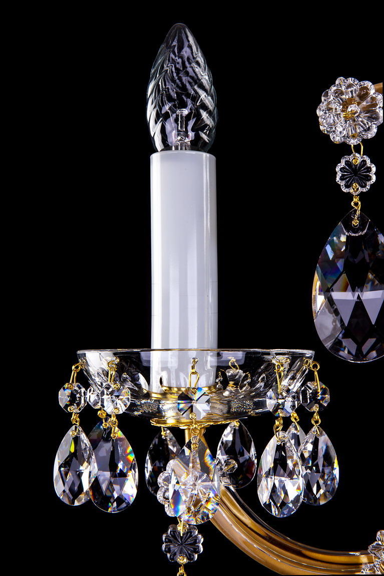 Détail du bras doré, douille blanche et collerette de cristal avec gouttes pendantes