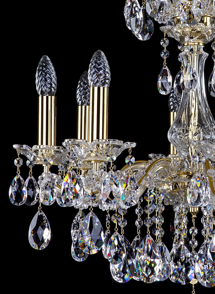 Détail des bras dorés, douilles bougeoirs et pendeloques de cristal taillé
